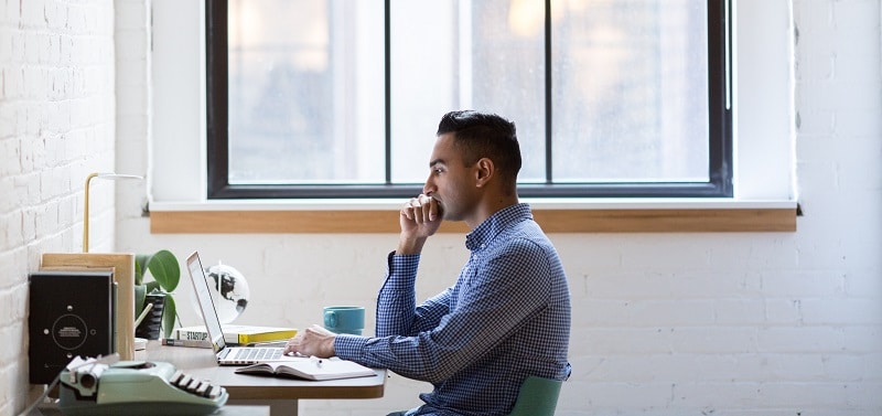 employee training to thwart cyber threats - employee sitting at desk looking at laptop