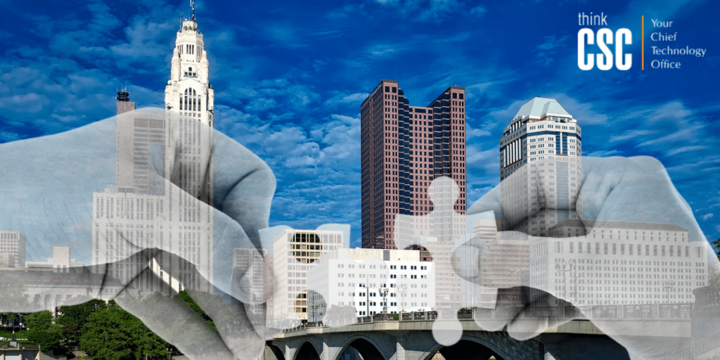 outsourcing IT makes good business sense - image is the columbus cityscape overlaid with semi-transparent hands meeting with fitting puzzle pieces